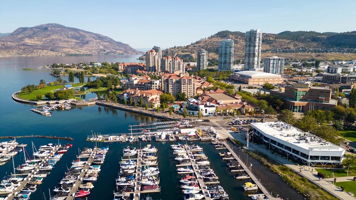 Kelowna waterfront with Okanagan Lake and vineyard hills at sunset