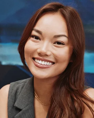 Annika Ng, smiling, in a grey sleeveless blazer