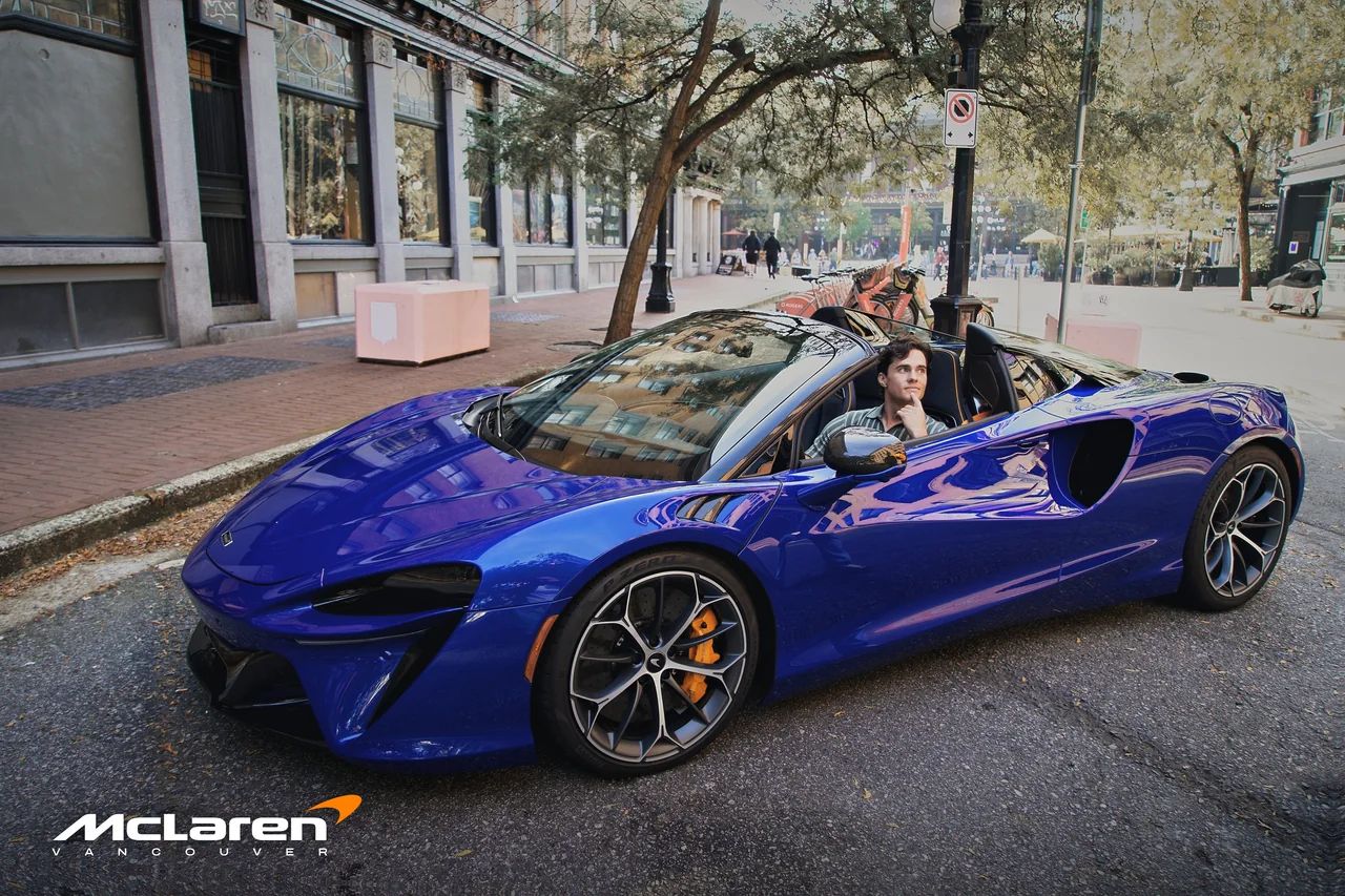 The Artura Spider with the roof down and a driver at the wheel.