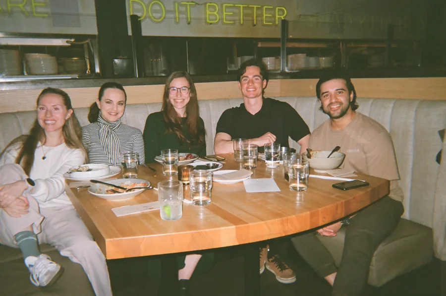Five members around a restaurant table at a Founder Feast dinner
