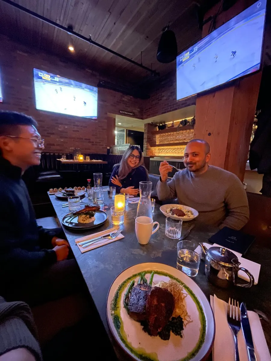 Three founders laughing over dinner at a Founder Feast event
